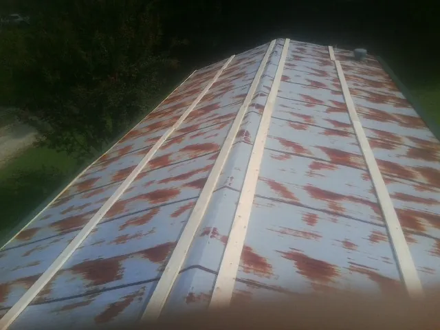 Rusted metal roof panels with new wood purlins before replacement — Storm Damage Roof Repair in Efland by Roofing Brothers