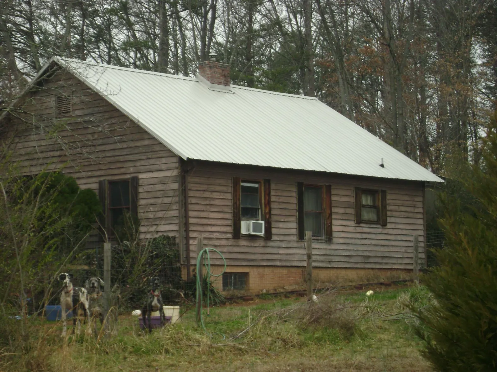 White metal roof on an old wood sided farmhouse, from a Asphalt Shingle Roof Repair job in Efland